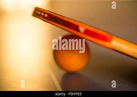 Ping pong palla e racket giacente sul tavolo con sfocati ed effetto artistico Foto Stock