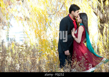 Indian uomo baciando la fronte della sposa Foto Stock