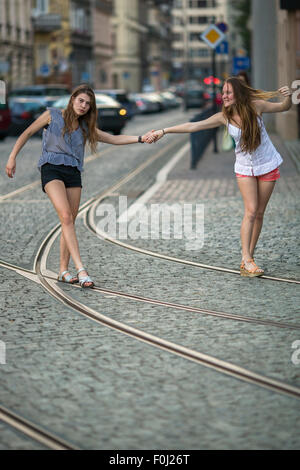 Due ragazze allegro amico andavamo insieme attraverso la strada. Foto Stock