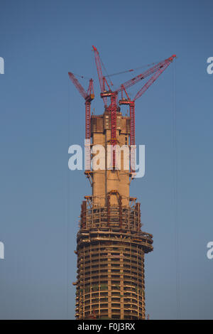 Il grattacielo in costruzione a Shanghai contro un cielo blu ed una luce arancione. Foto Stock