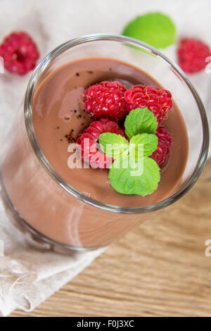 Mousse al cioccolato con lampone e menta nella porzione del vetro Foto Stock