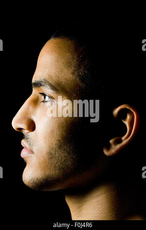 Vista Proile del giovane marocchino uomo nel buio Foto Stock