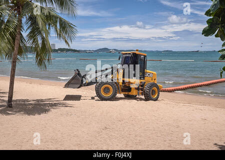 Il trattore escavatore a lavori di pulizia della spiaggia. Pattaya Thailandia SUDEST ASIATICO Foto Stock