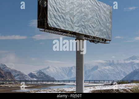 Segno road con paesaggio tibetano e un lungo ponte. L'Himalaya Mountain Range sono in background. Cina 2013 Foto Stock