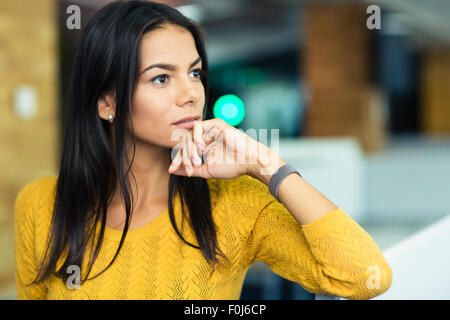 Ritratto di un pensieroso imprenditrice in piedi in ufficio Foto Stock