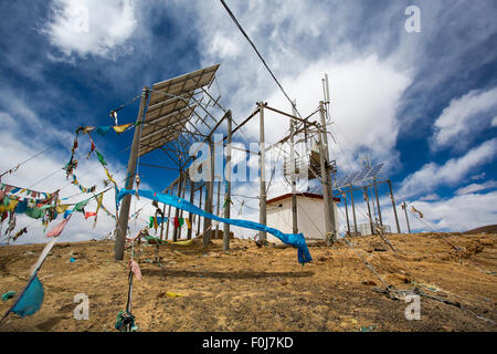 Installazione di telecomunicazioni sulla cima di una montagna in Tibet con la preghiera i tessuti sotto un cielo blu. Foto Stock