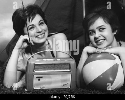 Radio, due donne con radio portatile "Babette" di Philips sdraiata davanti alla tenda, anni '50, diritti aggiuntivi-clearences-non disponibile Foto Stock