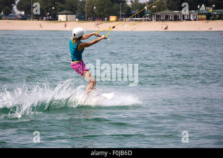 Ragazza giovane wakeboarder in azione sul lago Foto Stock