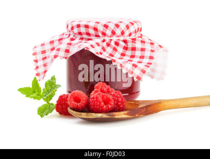 Lamponi sulla cucina in legno cucchiaio nella parte anteriore del vasetto di marmellata isolati su sfondo bianco Foto Stock