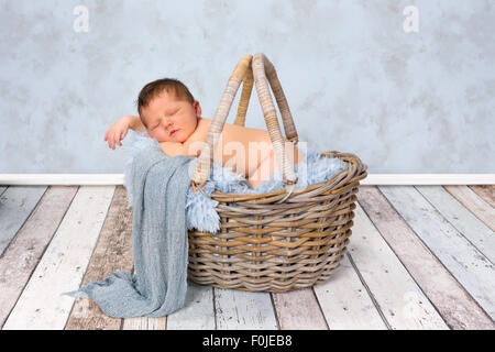 Adorabili sette giorni neonato ragazzo in un cesto di vimini Foto Stock