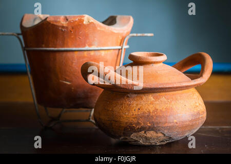 Vecchia pentola di creta con crepe su legno. Foto Stock