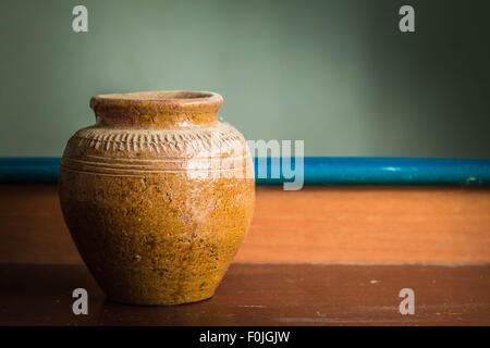 Vecchio vaso che si siede su un tavolo di legno. Foto Stock