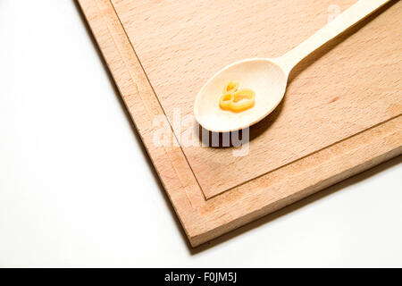 La pasta in forma di animali e un cucchiaio di legno su sfondo bianco Foto Stock