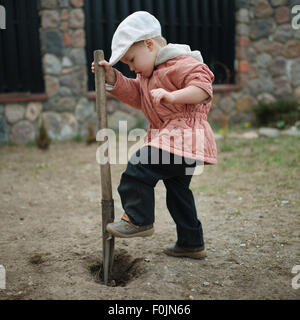 Little Boy scavando un foro Foto Stock