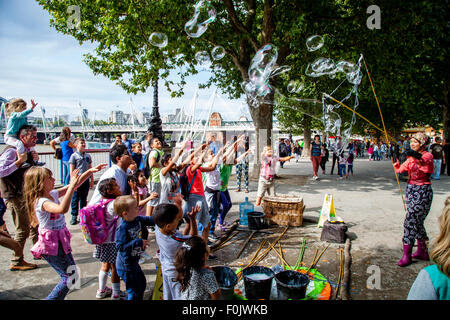 Un animatore di strada e la sua bolla mostra, Southbank, Londra, Inghilterra Foto Stock