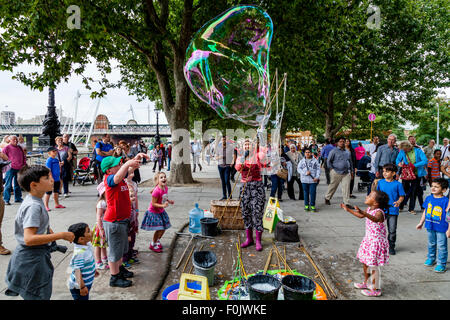 Un animatore di strada e la sua bolla mostra, Southbank, Londra, Inghilterra Foto Stock