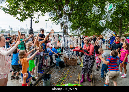 Un animatore di strada e la sua bolla mostra, Southbank, Londra, Inghilterra Foto Stock