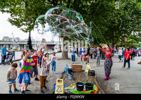 Un animatore di strada e la sua bolla mostra, Southbank, Londra, Inghilterra Foto Stock