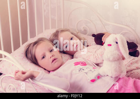 Little cute ragazze (suore) giocare nel letto. Messa a fuoco selettiva. Foto Stock