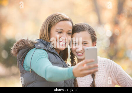 Madre e figlia tenendo selfie con la fotocamera del telefono all'aperto Foto Stock