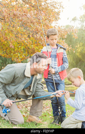 Padre figli di insegnamento per preparare le canne da pesca Foto Stock