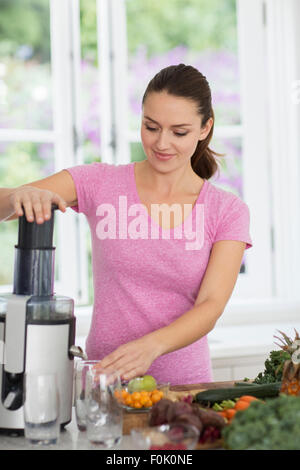 La donna a spremere il succo di frutta e verdura fresca Foto Stock