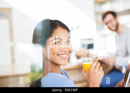 Ritratto di donna sorridente di bere succo di arancia Foto Stock