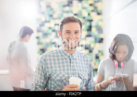 Ritratto fiducioso imprenditore creativo di bere il caffè in ufficio Foto Stock