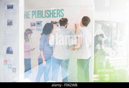 Il brainstorming di editori a lavagna in office Foto Stock