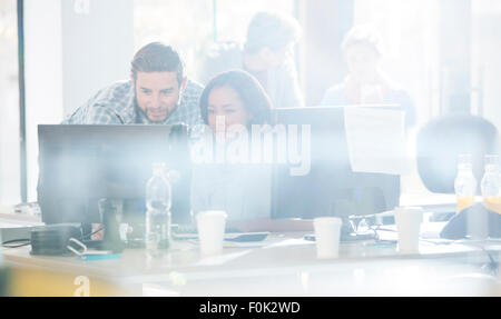 La gente di affari con computer in ufficio soleggiato Foto Stock