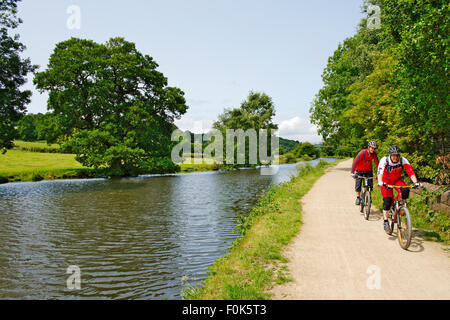 Escursioni in bicicletta lungo la Leeds e Liverpool canal tow-percorso sulla soleggiata giornata estiva, vicino Calverley Bridge, West Yorkshire Foto Stock