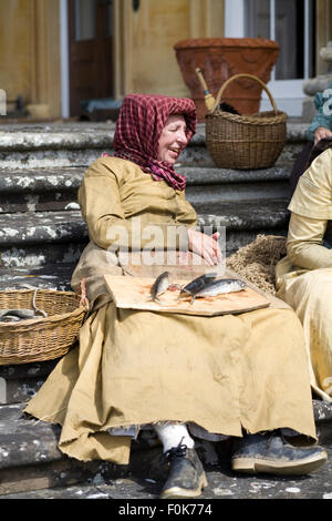 Fisher moglie seduta sui gradini di una casa padronale in epoca vittoriana Foto Stock