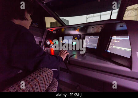 Shinkansen Museum di Nagoya. Sulla spalla del ragazzo caucasico, 10-12 anni, seduti al pannello di controllo e schermo video in bullet train simulator. Foto Stock