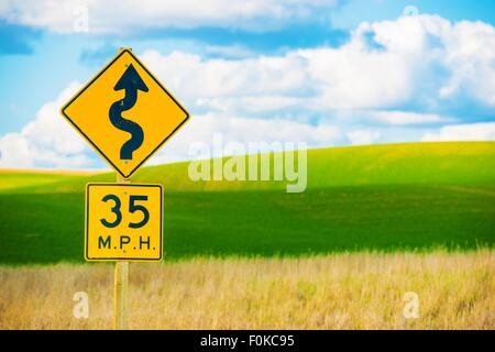 A destra strada tortuosa con forte giro simbolo. Strada strada curva segno. Foto Stock