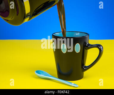 Il caffè fresco versando in tazza di fantasia sul piano del tavolo Foto Stock