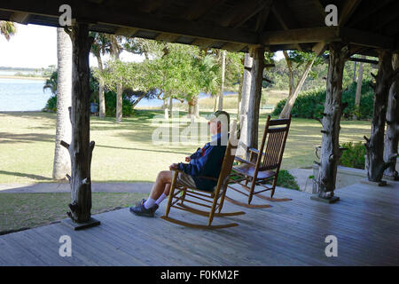 Uomo in una sedia a dondolo sotto il portico del lodge al posto della principessa preservare, Flagler county Florida Foto Stock