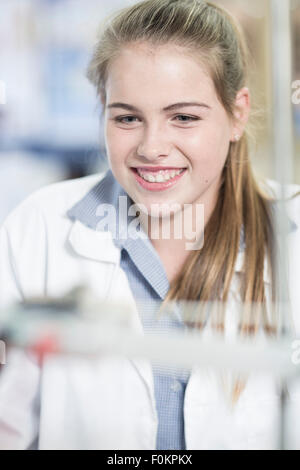 La scolaretta sorridente in classe fisica Foto Stock
