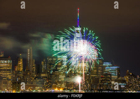 Fuochi d'artificio vengono sparati su Manhattan grattacielo laden skyline nella celebrazione conclusiva del Gay Pride la settimana a New York City. Foto Stock