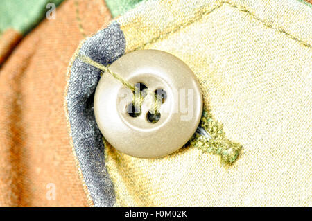 Ripresa macro di un esercito giacca pulsante verde Foto Stock