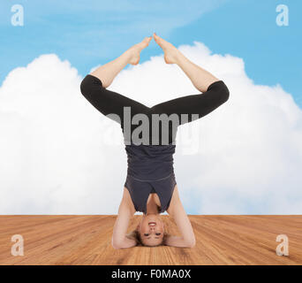 Felice giovane donna facendo esercizio di yoga Foto Stock