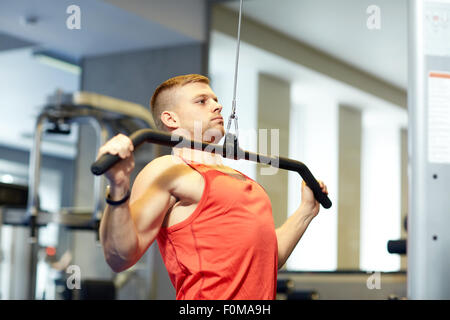 Uomo muscoli di flessione sul cavo macchina palestra Foto Stock