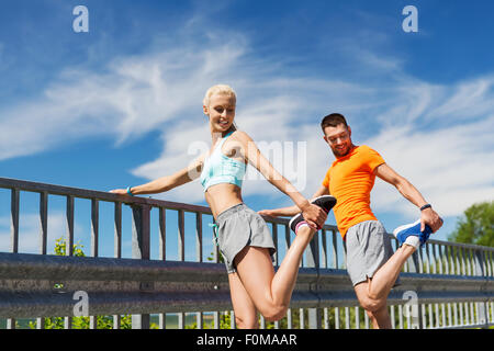 Coppia sorridente stretching all'aperto Foto Stock