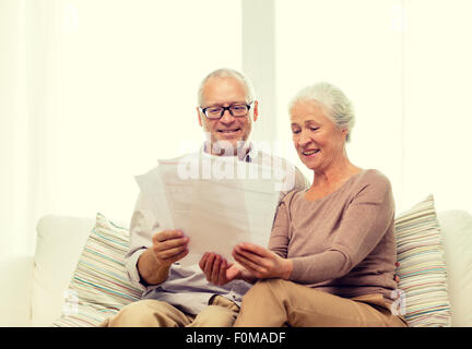 Felice coppia senior con documenti a casa Foto Stock