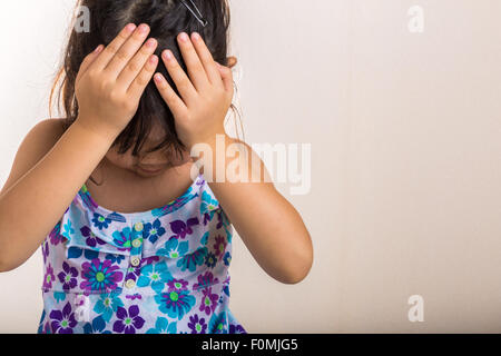 Bambina copre la fronte con le mani quando sentirsi deluso. Foto Stock