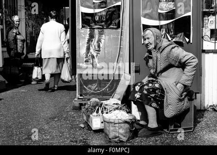 Anziano pensionato donna cerca le sue tasche mentre la visualizzazione homegrown produrre per la vendita Foto Stock