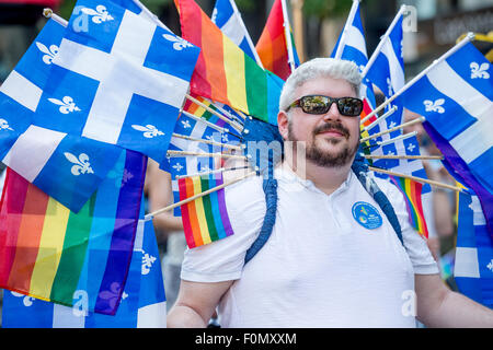 MONTREAL, Canada, 16 agosto 2015. Un partecipante gay sta portando molti quebec e gay rainbow bandiere del 2015 Gay Pride Parade di Montreal. © Marc Bruxelle/Alamy Live News Foto Stock