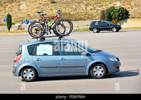 Vista laterale della bicicletta famiglia berlina caricato con biciclette sul portapacchi in partenza dal casello autostradale francese Provence-Alpes-Côte France EU Foto Stock