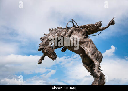 Statua di bronzo di cowboy a cavallo di contraccolpi scolpito da J.C. Colorante; Stanford, Montana. Foto Stock