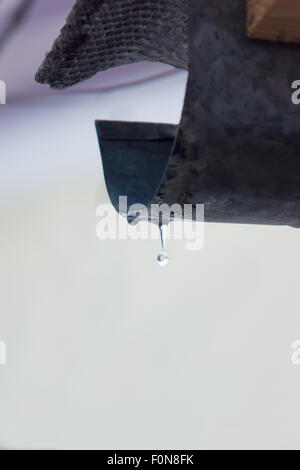 La caduta di acqua impiccato su un pozzo e è pronto a rompersi Foto Stock