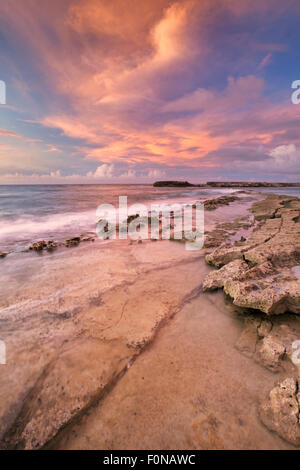 La rocciosa costa tropicale al tramonto. Fotografato a Playa Canoa su Curaçao, Antille Olandesi. Foto Stock